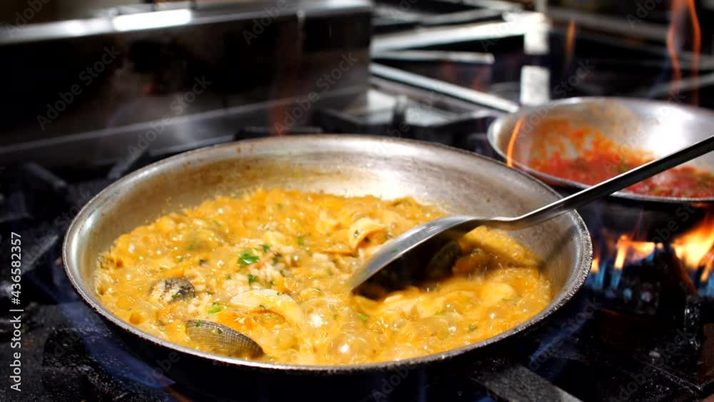 Chef preparing seafood risotto in restaurant, close-up, Mediterranean Chef preparing seafood risotto in restaurant, close-up, Mediterranean
