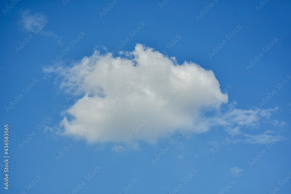 Beautiful cumulus clouds against the blue daytime sky.