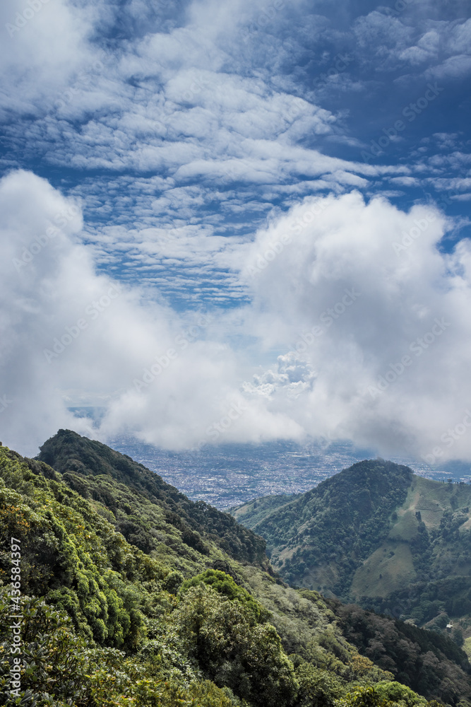 Mountains with grass and trees surrounding the capital of Costa Rica on a sunny day full of white clouds Mountains with grass and trees surrounding the capital of Costa Rica on a sunny day full of white clouds