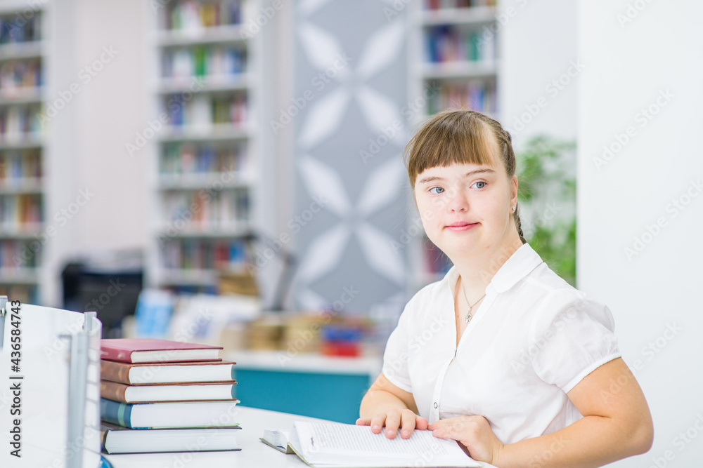 Portrait of a young girl with syndrome down at library. Education for disabled children concept Portrait of a young girl with syndrome down at library. Education for disabled children concept