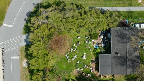 Descending aerial on backyard filled with junk, trash and debris. Homeowner with packrat tendencies.