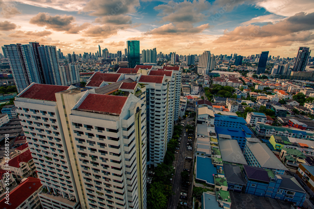 Naklejka premium The high angle background of the city view with the secret light of the evening, blurring of night lights, showing the distribution of condominiums, dense homes in the capital community