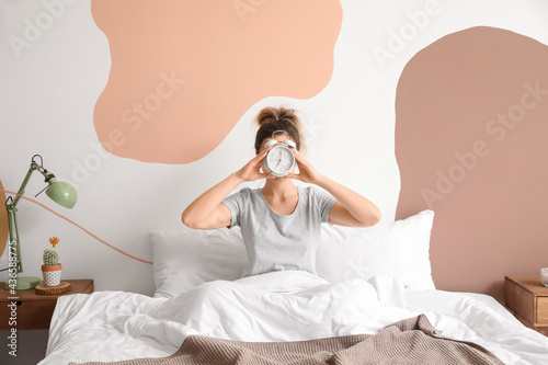Young woman with alarm cloc...
