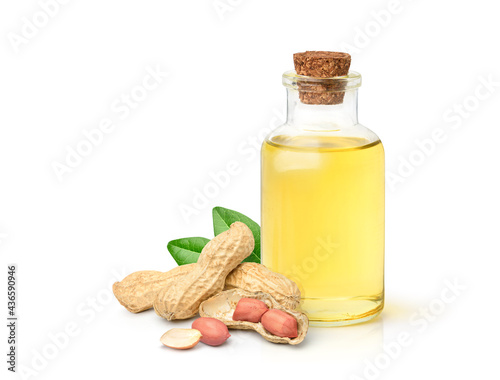 Peanut oil with peanuts and leaves isolated on white background. photo