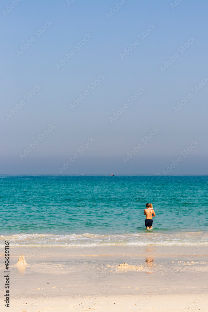 Teenage boy carrying little girl at the beach. Holiday