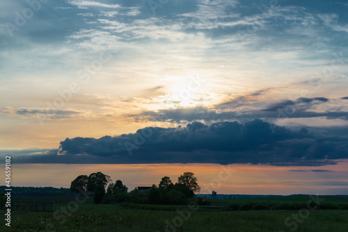The evening,morning cloud sun and field among trees In the warm summer weather,Nice colored evening summer landscape. © ARVD73