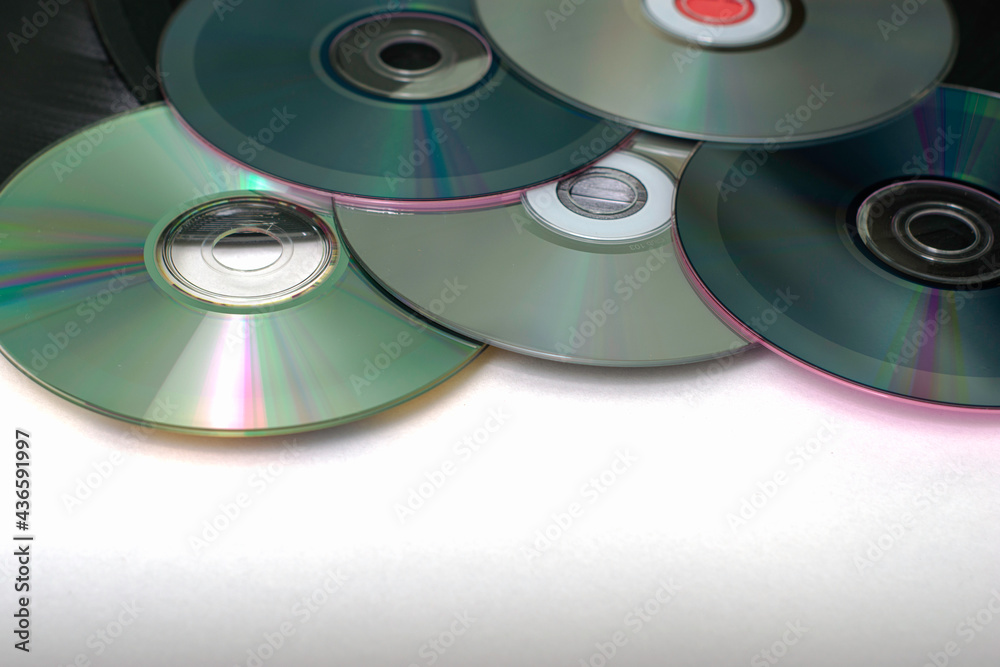 vinyl discs and CDs on a white surface concept storage of information progress vinyl discs and CDs on a white surface concept storage of information progress