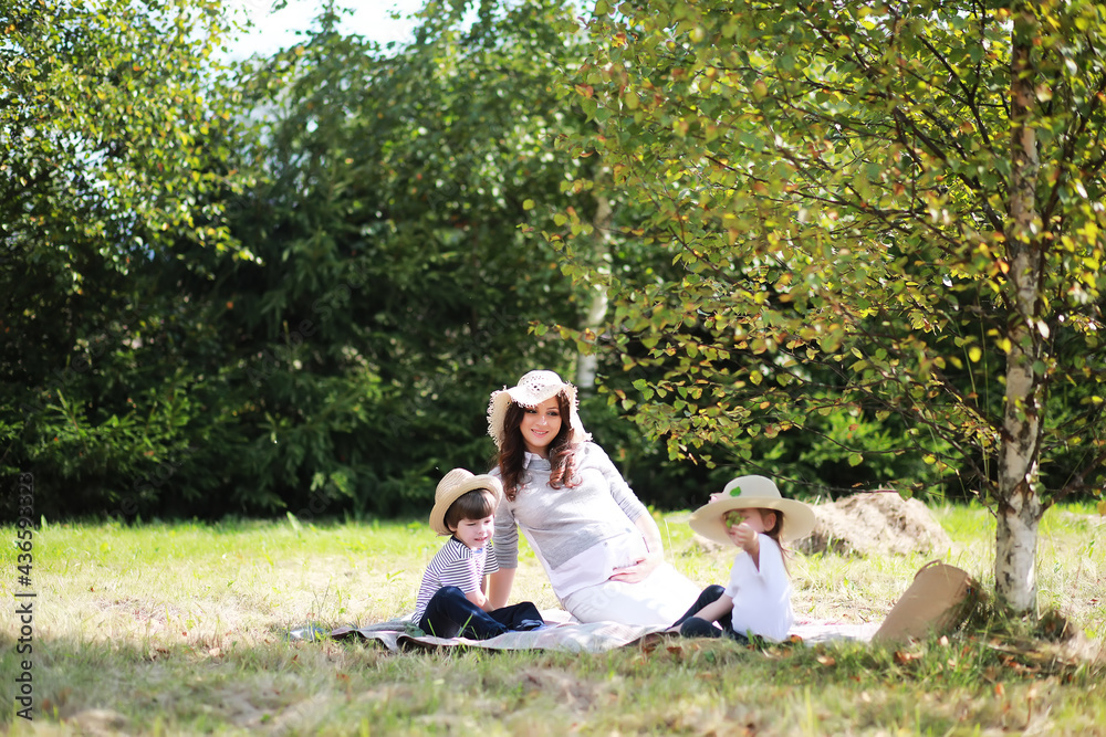 Happy family with children having picnic in park, parents with kids sitting on garden grass and eating watermelon outdoors Happy family with children having picnic in park, parents with kids sitting on garden grass and eating watermelon outdoors