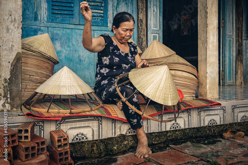 Obraz na płótnie Vietnamese Old woman craftsman making the traditional vietnam hat in the old traditional house in Ap Thoi Phuoc village, Hochiminh city, Vietnam, traditional artist concept w salonie