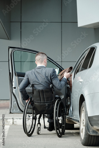 Back view of handicapped businessman in suit going to get into his car © pressmaster