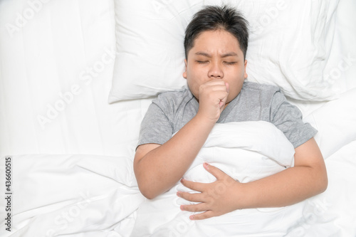 Asia boy is coughing and lying on bed, health care
