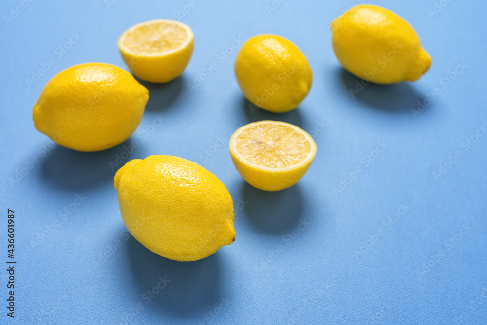 Fresh lemons on a blue paper background. Side view, selective focus. Fresh lemons on a blue paper background. Side view, selective focus.
