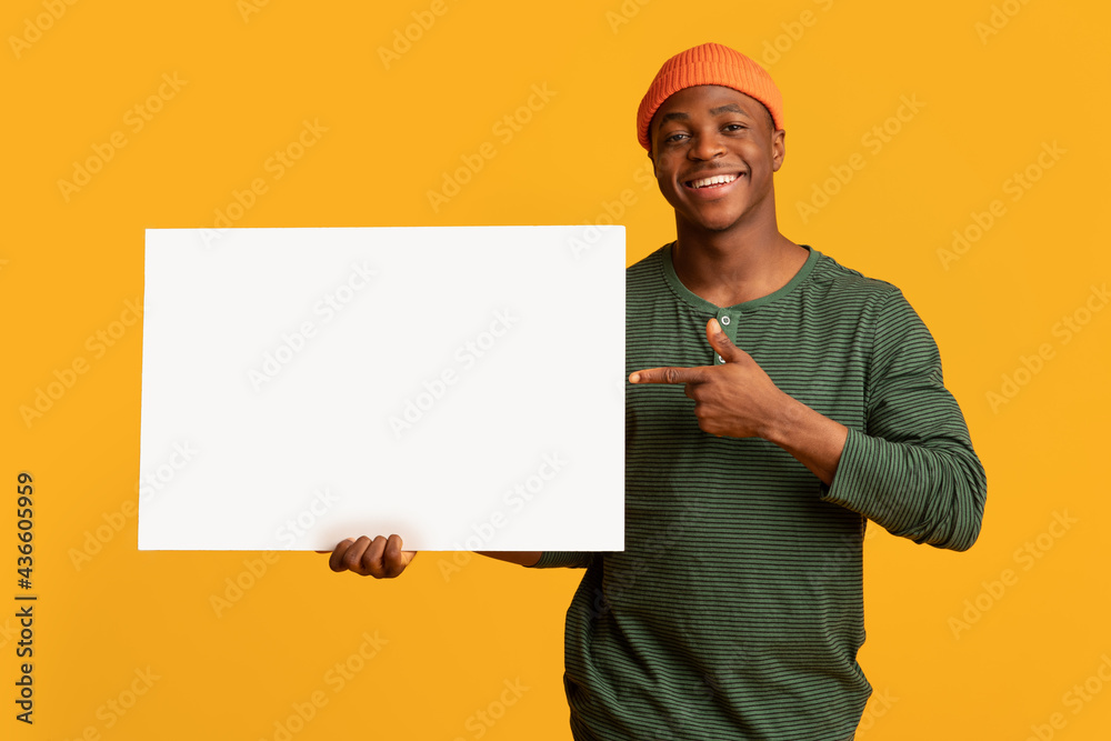 Place For Your Ad. Cheeful Black Hipster Guy Pointing At White Placard Place For Your Ad. Cheeful Black Hipster Guy Pointing At White Placard