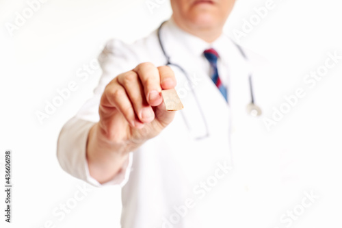 Close up, hand of a doctor holding tongue depressor. Health concept