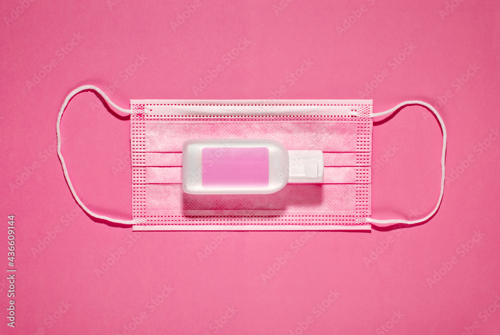 Pink medical mask and bottle of disinfecting gel Pink medical mask and bottle of disinfecting gel