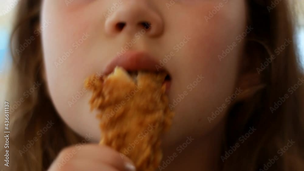 Baby girl eating nuggets close up. Female mouth eats fast food. Baby girl eating nuggets close up. Female mouth eats fast food.