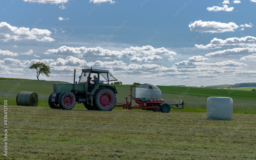 Fototapeta premium tracteur enrubannage des balles de foin avec film plastique
