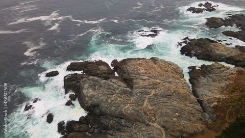 AERIAL - Rocky shore in Zapallar, Valparaiso, Chile, wide spinning shot photo