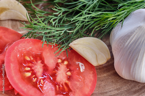 fresh tomato slice, fresh green dill, garlic clove and slice, daylight, close-up