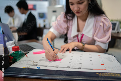 female asian with writing plan in office 