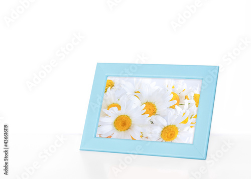 Photo frame with beautiful white camomiles picture  interior decor detail idea