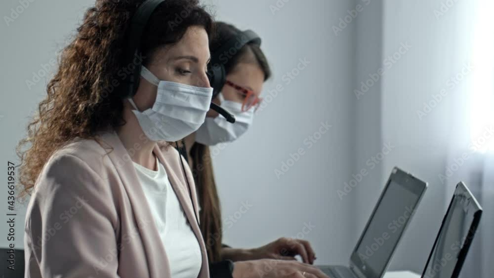 Call center operators in medical masks. Office work during the coronavirus epidemic.