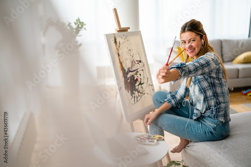 Art, creativity, hobby, job and creative occupation concept. Woman painting at home.
