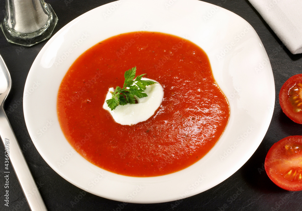 Tomato Soup with sour Cream in a Bowl on black Background Tomato Soup with sour Cream in a Bowl on black Background