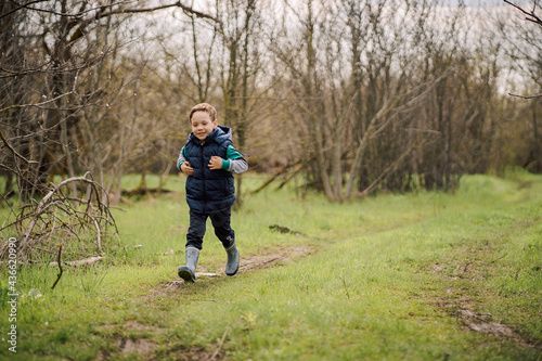 the boy walks along the forest path