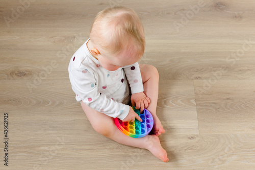 Little kid plays with trendy Pop it fidget toy
