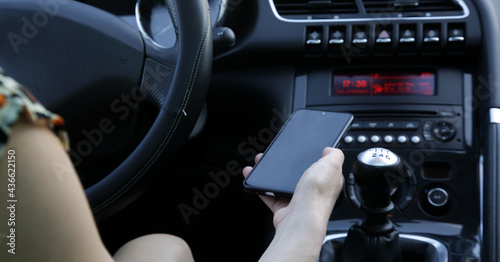 Woman is pairing her phone with car music system via bluetooth photo