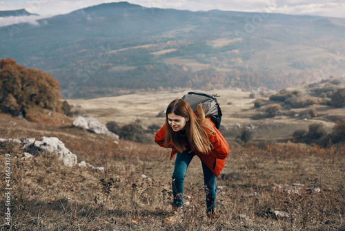 woman hiker in jacket boots with backpack travel in mountains landscape