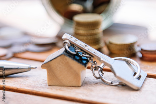 mortgage and investment concept. key with keychain house and coins