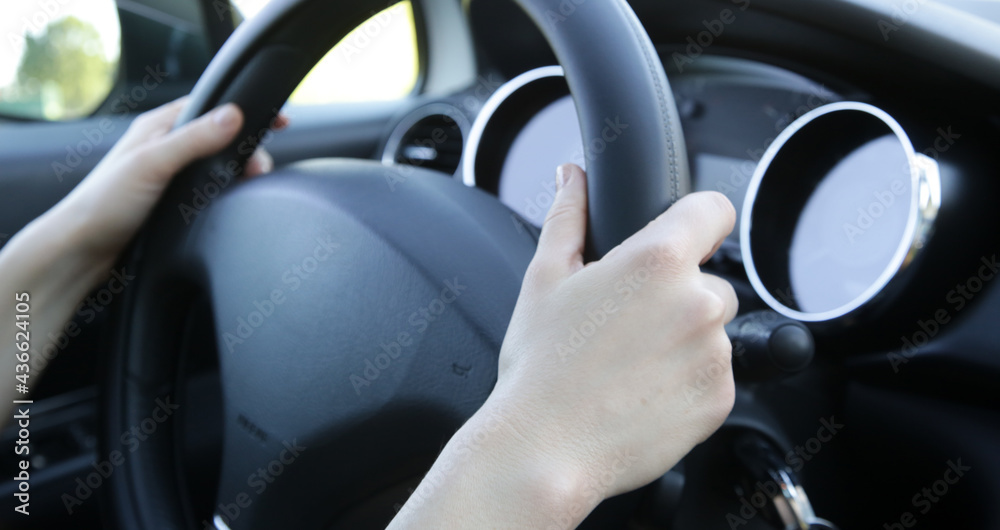Woman hands on steering wheel, close up