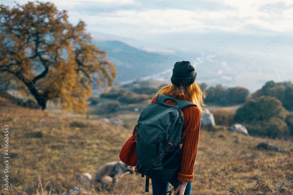 cheerful woman creates a backpack on a trip walk landscape