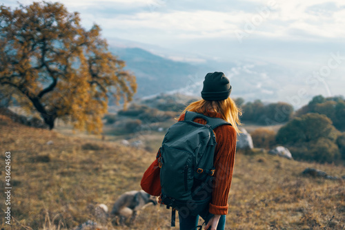 cheerful woman creates a backpack on a trip walk landscape