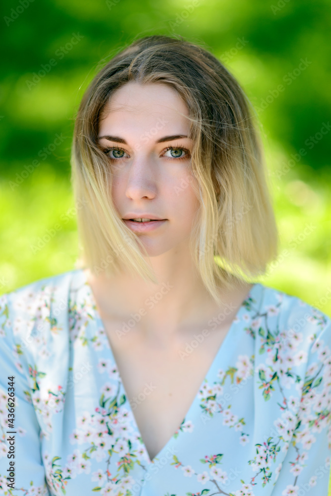 Outdoors portrait of beautiful young woman with green eyes.