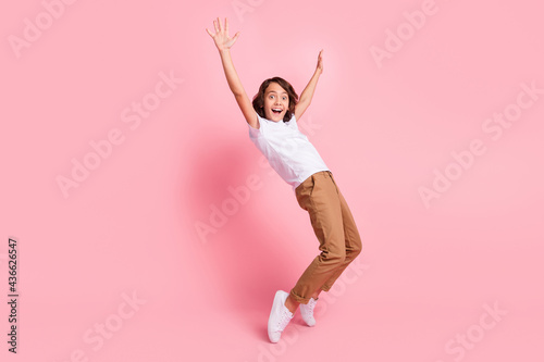 Full size photo of cheerful positive amazed little boy raise hands good mood isolated on pink color background