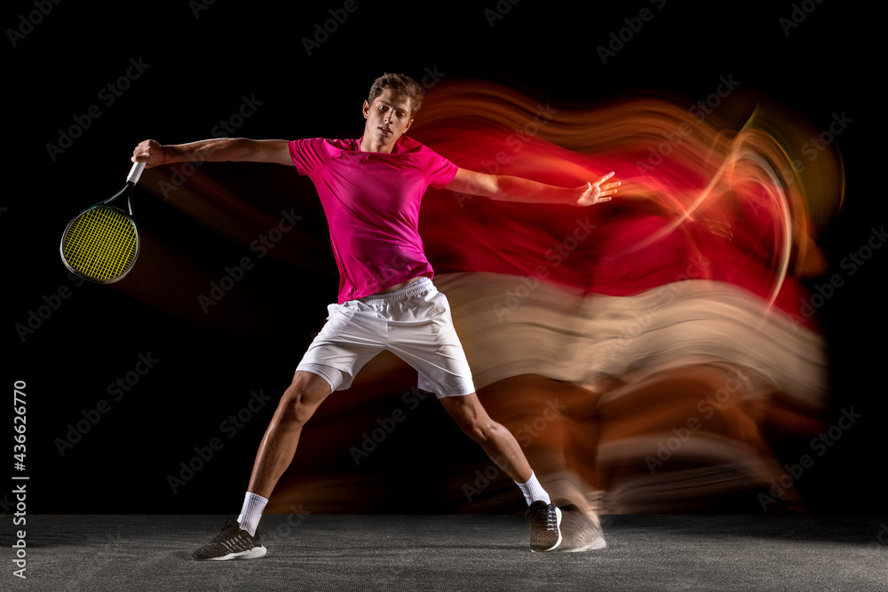 One man, male tennis player training isolated in mixed neon light on dark background. Concept of sport, team competition.