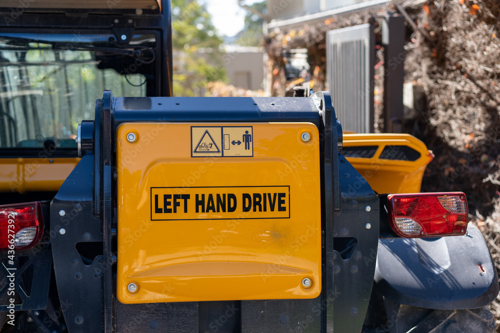 truck on construction site with sign saying Left Hand Drive on truck