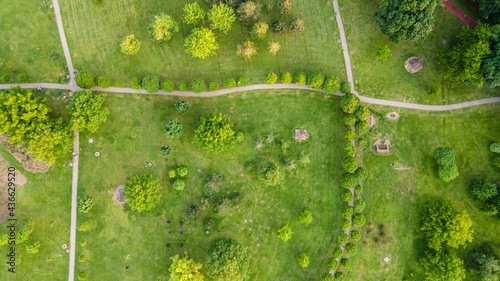 Urban park with meadow, trees and paths. Top view aerial photo from flying drone of a city park with walking path and green zone trees in evening time. photo