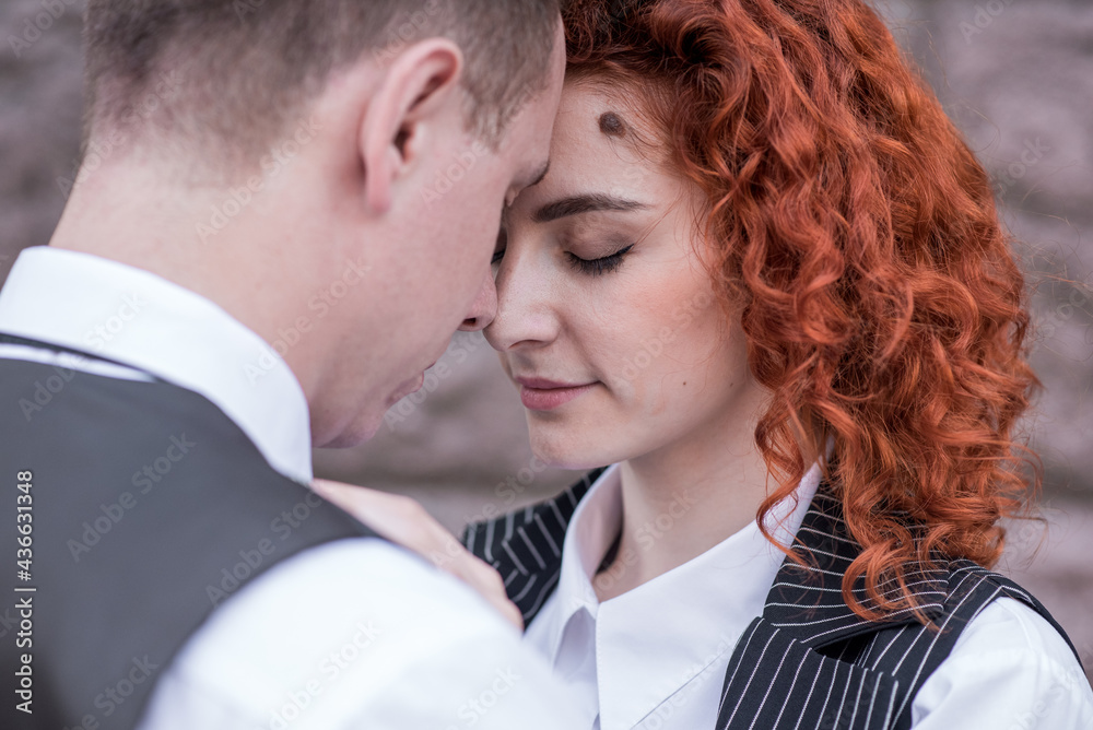 Happy redhead husband and wife standing and hugging on the street Happy redhead husband and wife standing and hugging on the street