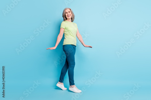 Fototapeta Naklejka Na Ścianę i Meble -  Full length body size photo senior business woman walking forward cheerful isolated pastel blue color background