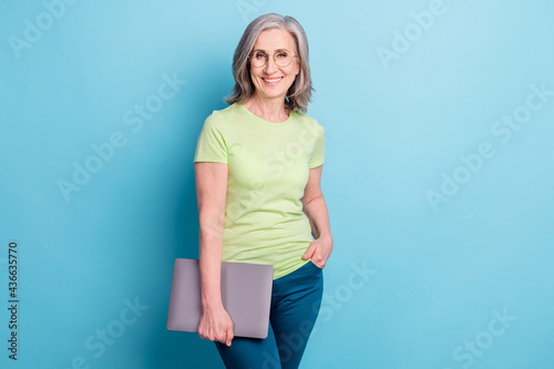 Photo of attractive charming old woman hold hands laptop wear glasses smile isolated on blue color background © deagreez