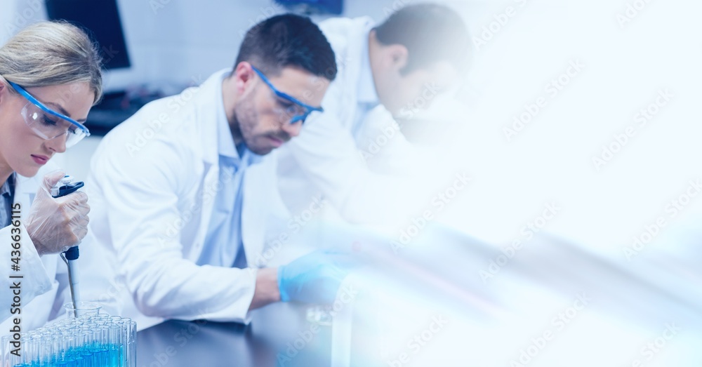 Composition of male and female lab technicians at work, with blurred copy space to right