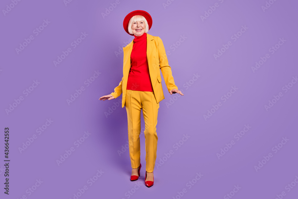 Full body photo of optimistic nice short hairdo elder lady wear yellow suit cap isolated on purple background Full body photo of optimistic nice short hairdo elder lady wear yellow suit cap isolated on purple background