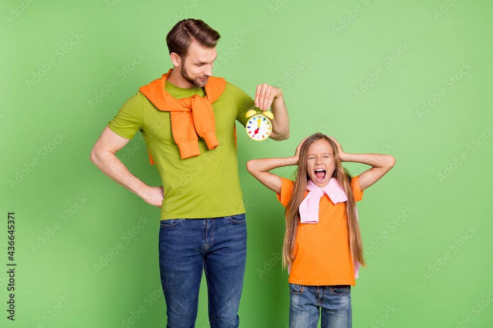 Portrait of nice trendy crazy upset people dad holding clock girl screaming isolated over green color background Portrait of nice trendy crazy upset people dad holding clock girl screaming isolated over green color background