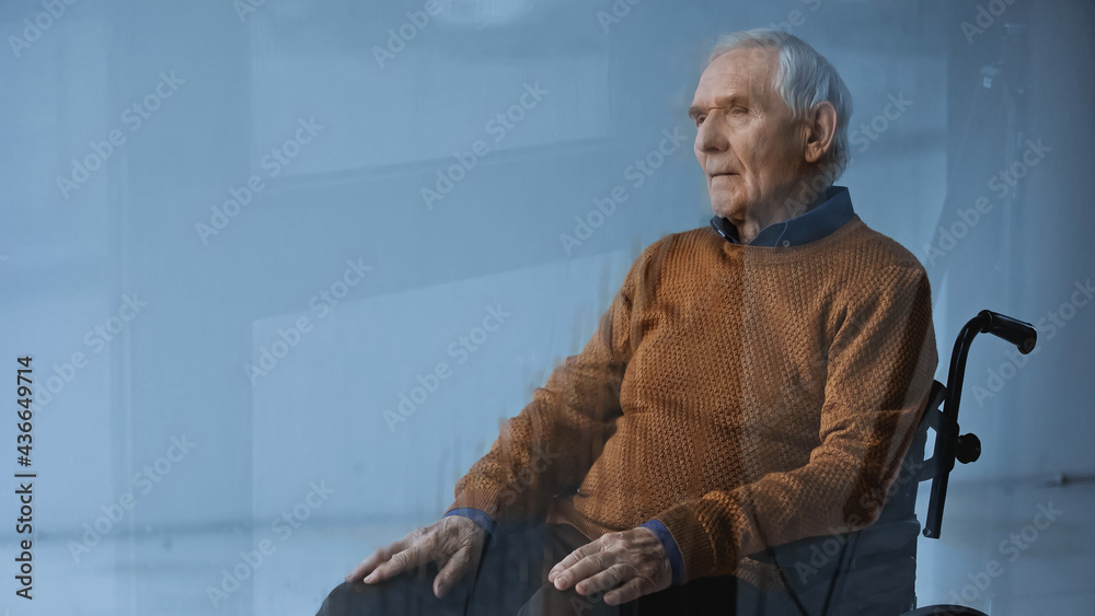 thoughtful senior man in wheelchair looking away on grey background. thoughtful senior man in wheelchair looking away on grey background.
