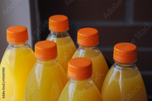 Close up on the multi-pack of plastic bottles with orange juice