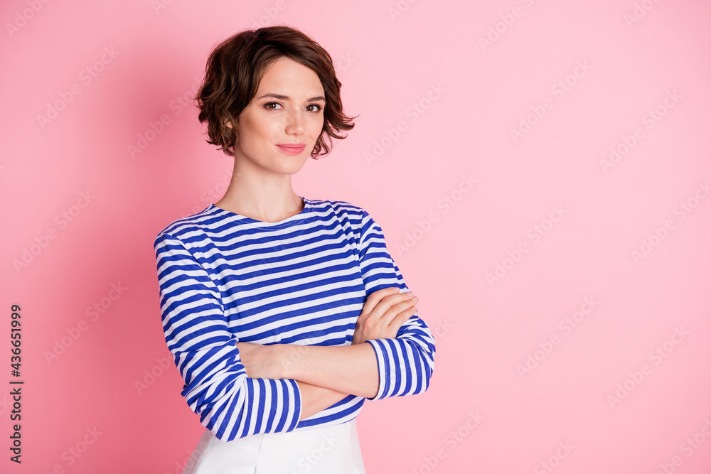 Photo of charming lady crossed arms self-assured look camera smile wear striped shirt isolated pastel pink color background Photo of charming lady crossed arms self-assured look camera smile wear striped shirt isolated pastel pink color background